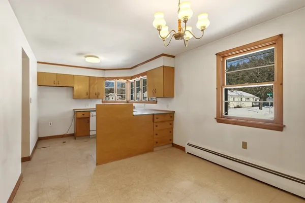 a kitchen with a refrigerator a sink dishwasher a stove and a dining table with wooden floor