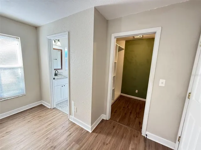 an empty room with wooden floor and entrance