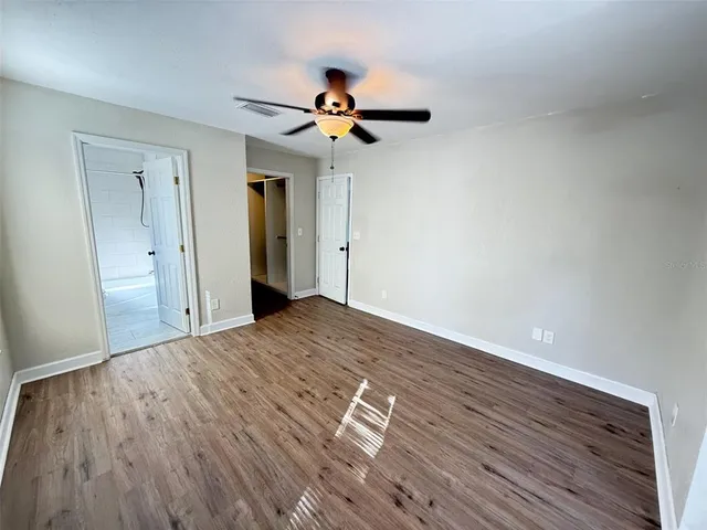 a view of empty room with wooden floor