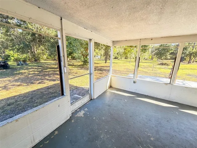 a view of an empty room with wooden floor and iron stairs