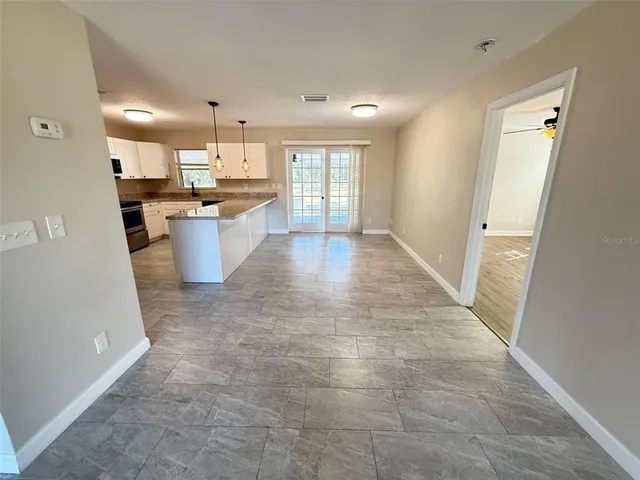 a view of a kitchen with furniture and a refrigerator