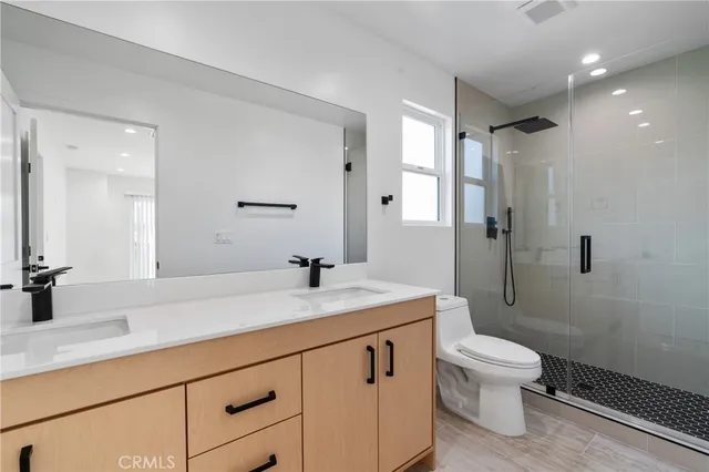 a bathroom with a granite countertop sink a toilet and shower