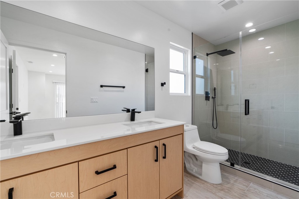 11140 Woodley Avenue, Unit 1/2 Granada Hills, CA 91344 - Photo 13 of 20 a bathroom with a granite countertop sink a toilet and shower