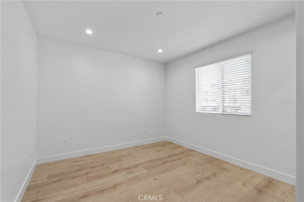 11140 Woodley Avenue, Unit 1/2 Granada Hills, CA 91344 - Photo 14 of 20 an empty room with wooden floor and windows