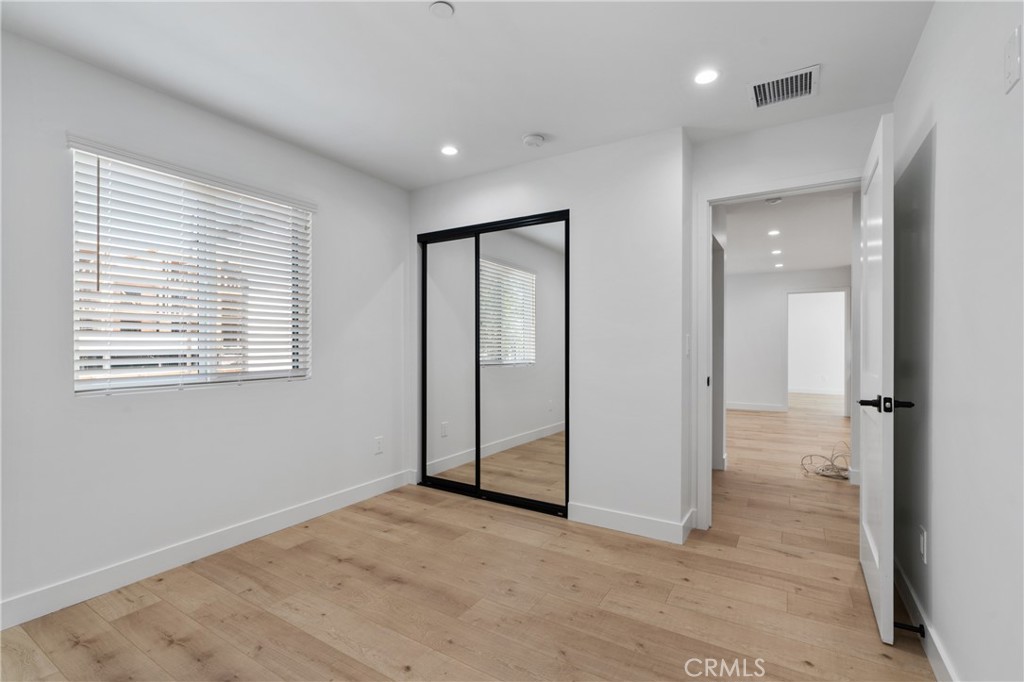 11140 Woodley Avenue, Unit 1/2 Granada Hills, CA 91344 - Photo 15 of 20 a view of an empty room with wooden floor and a window