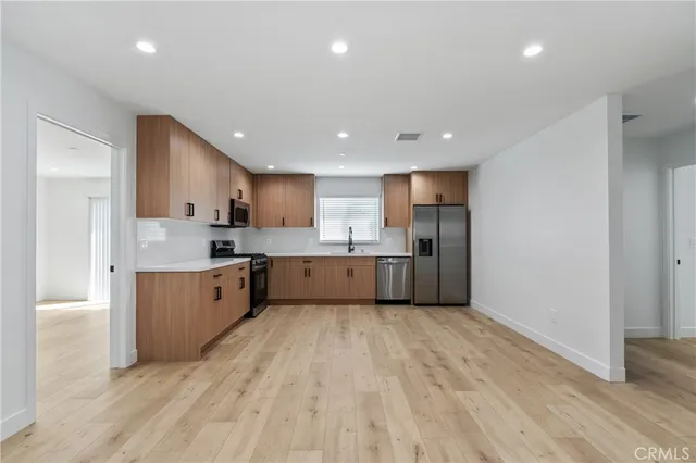 a large kitchen with a lot of counter space stainless steel appliances and cabinets