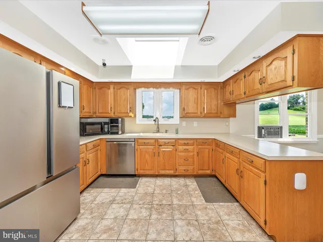 a kitchen with granite countertop a refrigerator and cabinets