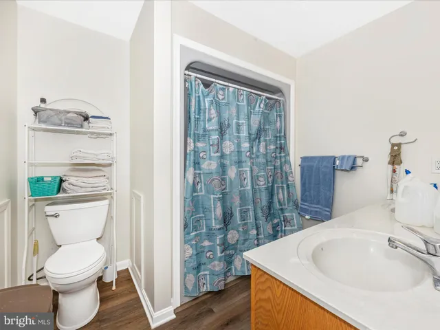 a view of a kitchen with stainless steel appliances wooden floor and living room