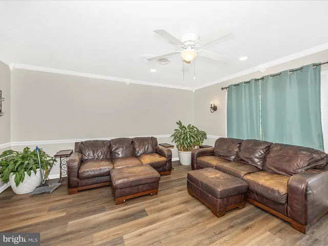 a living room with furniture and a flat screen tv with wooden floor