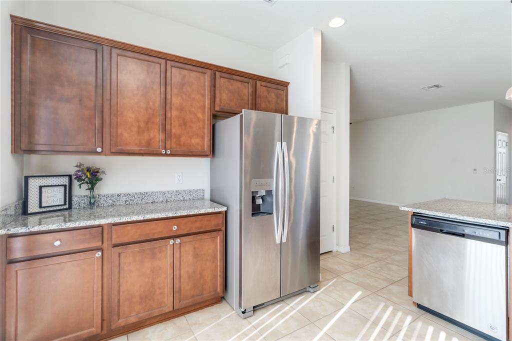 3566 Southern Cross Loop Kissimmee, FL 34744 - Photo 12 of 32 a kitchen with stainless steel appliances granite countertop a refrigerator and a sink