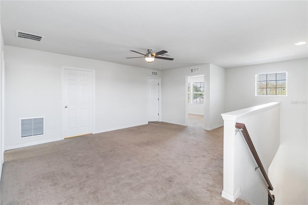 3566 Southern Cross Loop Kissimmee, FL 34744 - Photo 17 of 32 an empty room with windows and ceiling fan