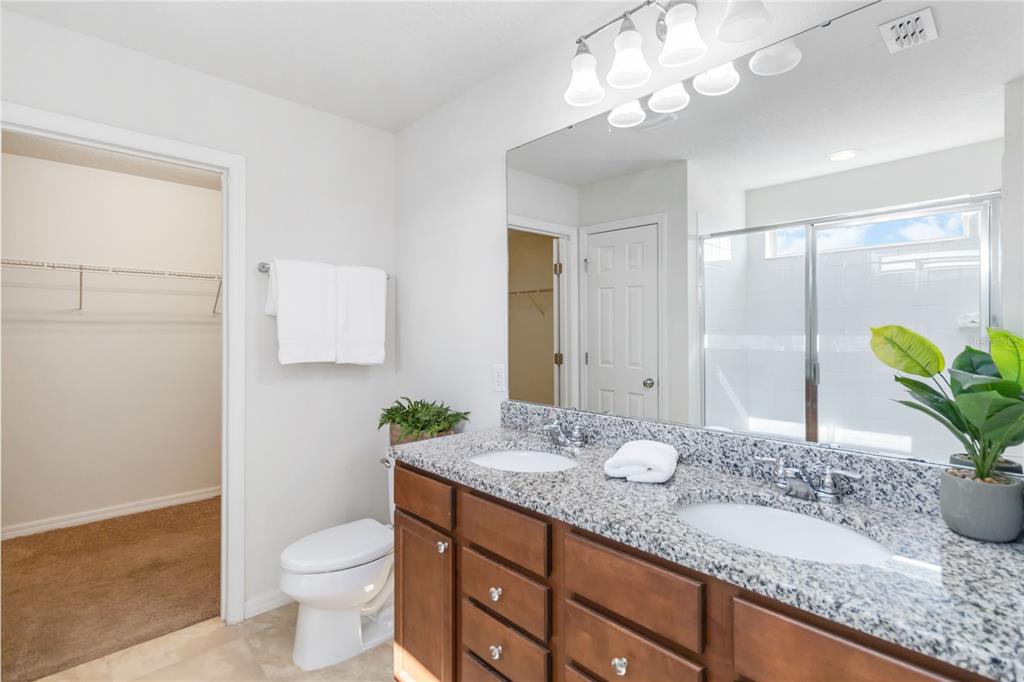 3566 Southern Cross Loop Kissimmee, FL 34744 - Photo 22 of 32 a bathroom with a granite countertop sink and a mirror