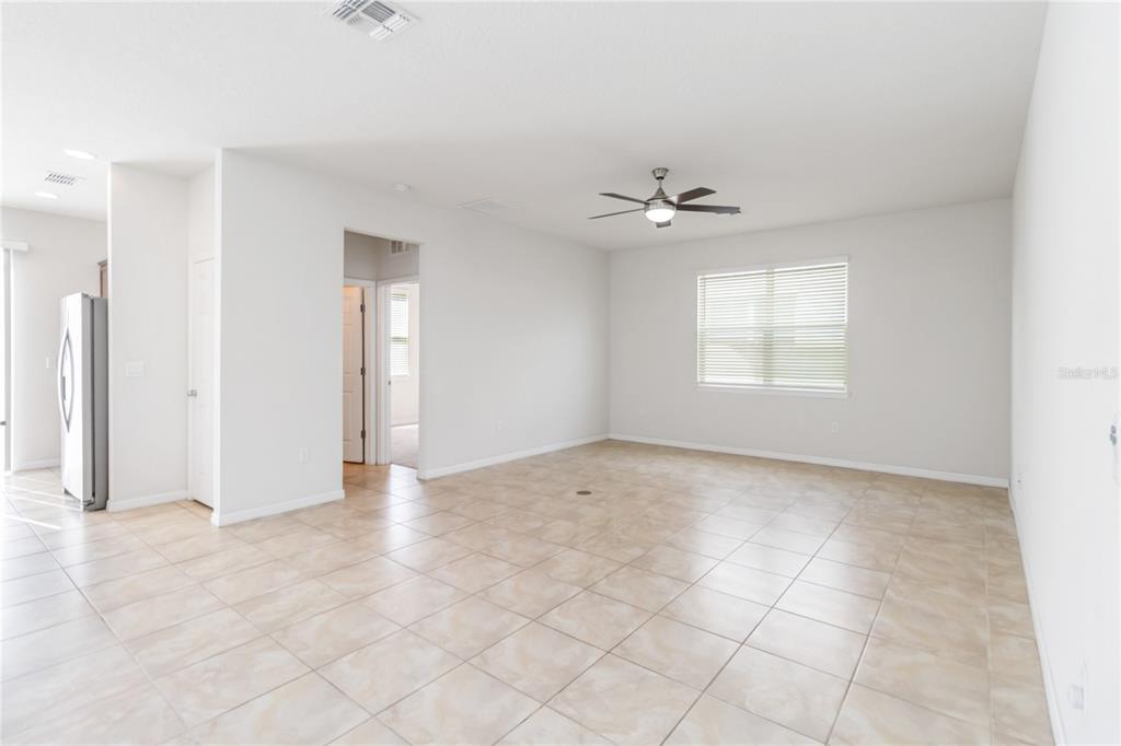 3566 Southern Cross Loop Kissimmee, FL 34744 - Photo 6 of 32 an empty room with windows and ceiling fan