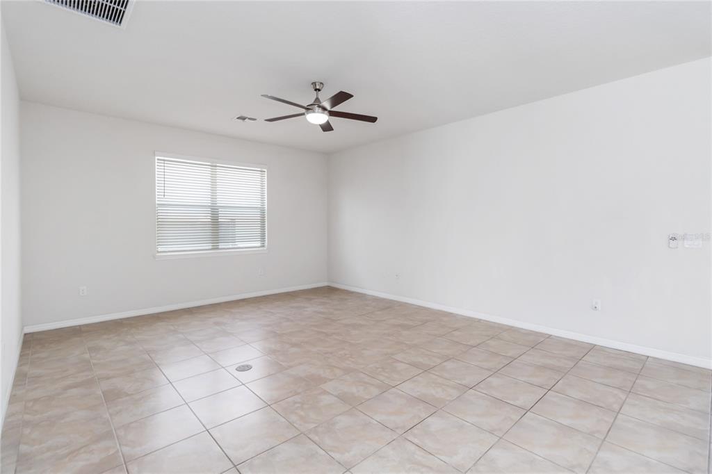 3566 Southern Cross Loop Kissimmee, FL 34744 - Photo 7 of 32 an empty room with windows and fan