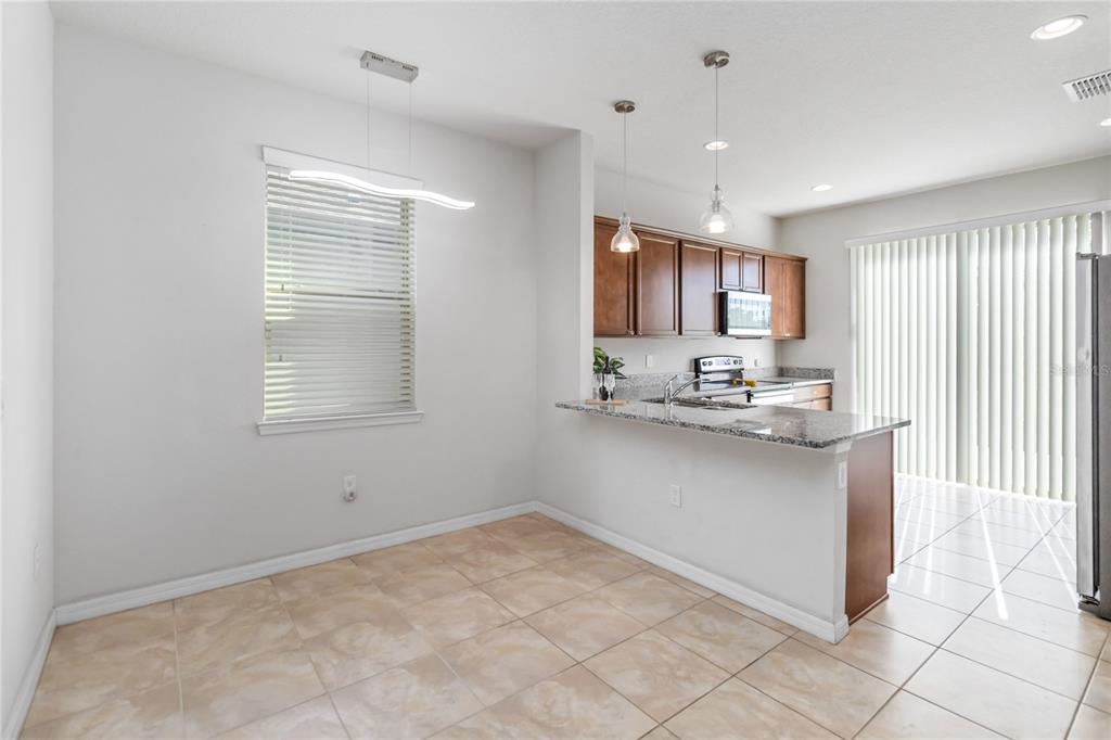 3566 Southern Cross Loop Kissimmee, FL 34744 - Photo 9 of 32 a kitchen with stainless steel appliances granite countertop a stove and a refrigerator
