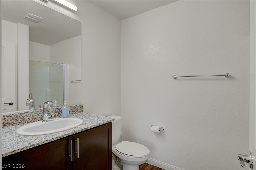 6924 Spicy Merlot Street North Las Vegas, NV 89086 - Photo 27 of 83 A well-appointed bathroom featuring a contemporary vanity with a granite countertop and a spacious mirror.