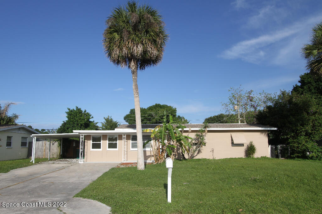 114 1st Street Merritt Island, FL 32953 - Photo 1 of 21 a front view of a house with a yard and garage