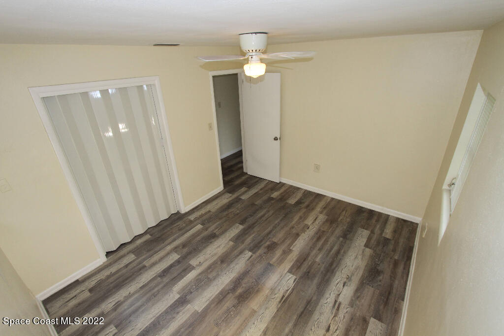 114 1st Street Merritt Island, FL 32953 - Photo 15 of 21 a view of a room with wooden floor and a ceiling fan
