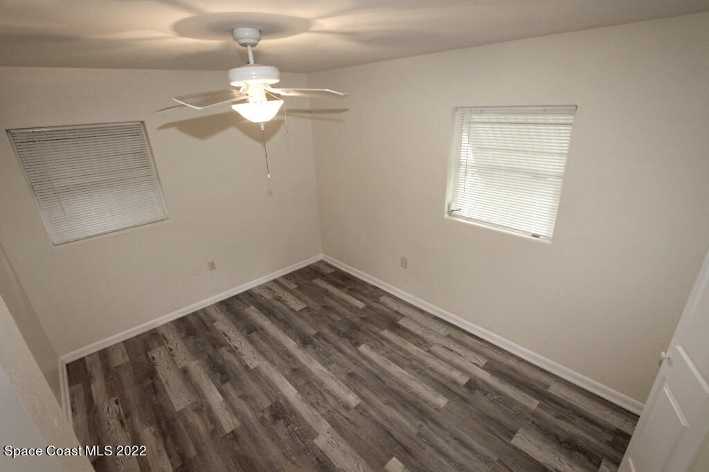 114 1st Street Merritt Island, FL 32953 - Photo 16 of 21 a view of a room with wooden floor and chandelier fan