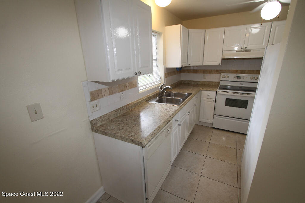 114 1st Street Merritt Island, FL 32953 - Photo 9 of 21 a kitchen with stainless steel appliances granite countertop a stove a sink and a refrigerator
