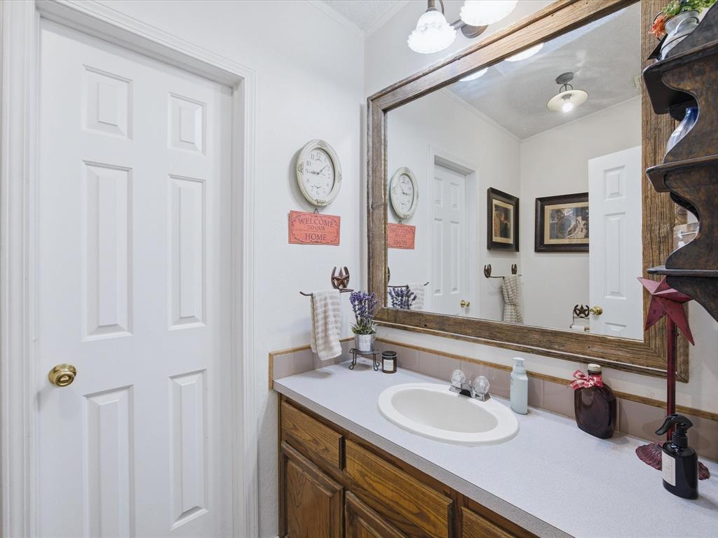 3275 Finis Road Graham, TX 76450 - Photo 25 of 36 a bathroom with a sink vanity and mirror