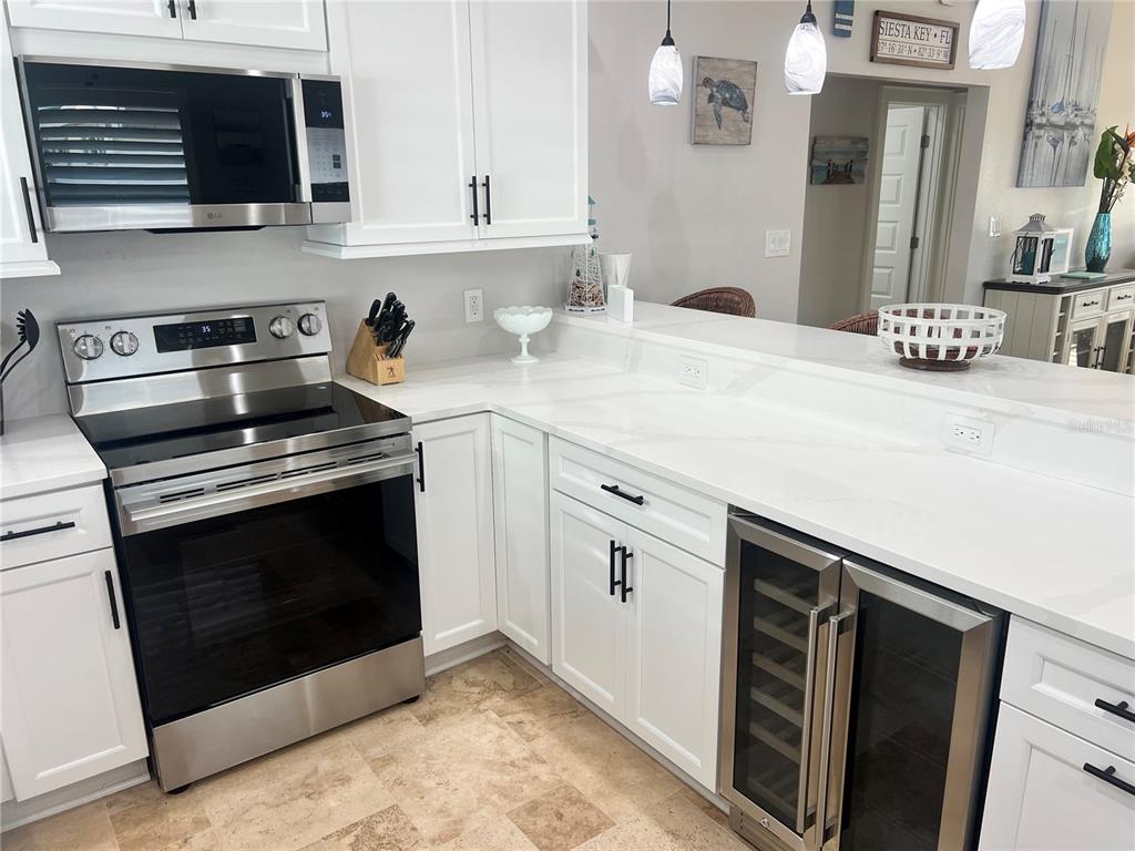 6020 Midnight Pass Road, Unit 22 Sarasota, FL 34242 - Photo 11 of 21 a kitchen with stainless steel appliances a stove microwave and sink