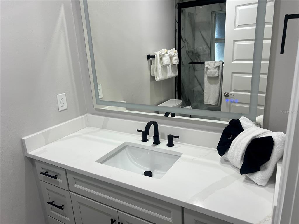 6020 Midnight Pass Road, Unit 22 Sarasota, FL 34242 - Photo 14 of 21 a bathroom with a sink and a mirror