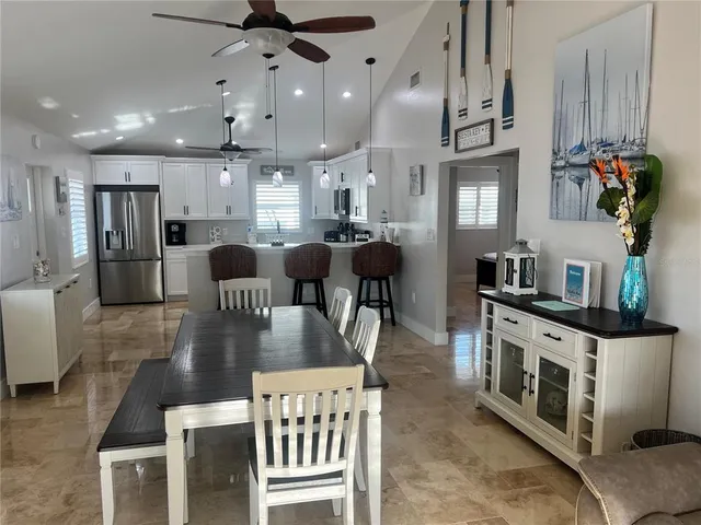 a kitchen with stainless steel appliances kitchen island granite countertop a table chairs stove a refrigerator a couch and a dining table