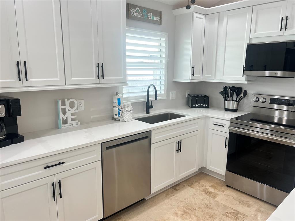 6020 Midnight Pass Road, Unit 22 Sarasota, FL 34242 - Photo 10 of 21 a kitchen with white cabinets and white appliances