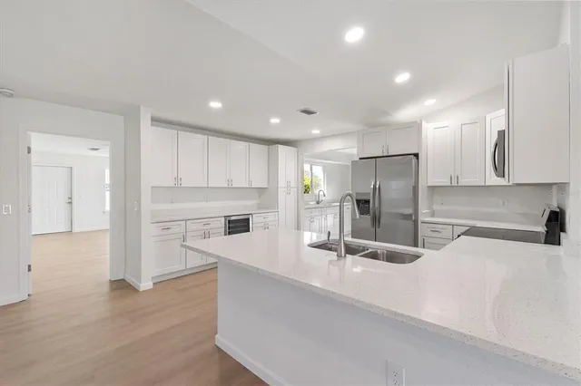 a kitchen with stainless steel appliances granite countertop a refrigerator and a sink