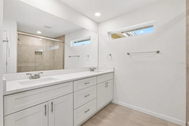 a spacious bathroom with a double vanity sink and mirror