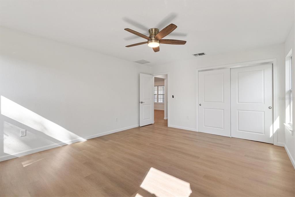 11041 Southeast 174th Loop Summerfield, FL 34491 - Photo 37 of 43 a view of empty room with wooden floor and ceiling fan