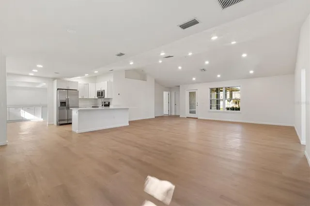 a view of an empty room with a kitchen
