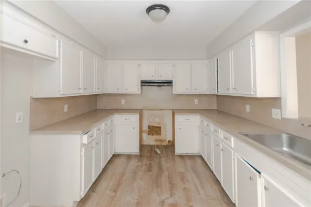 a kitchen with granite countertop a sink and cabinets