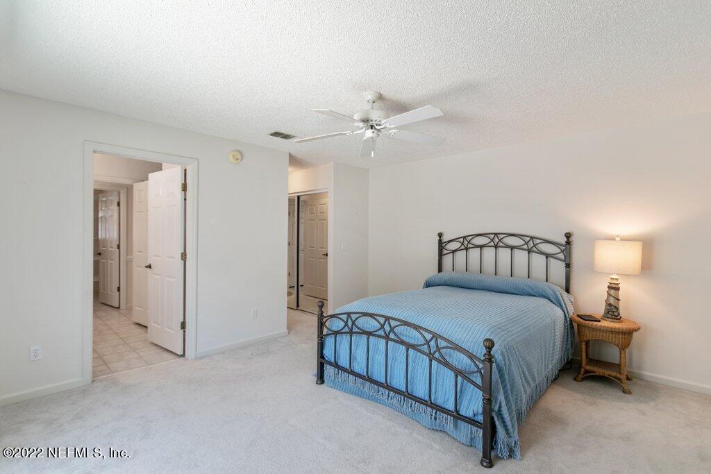409 Village Drive St. Augustine, FL 32084 - Photo 18 of 75 a bedroom with a bed and a ceiling fan