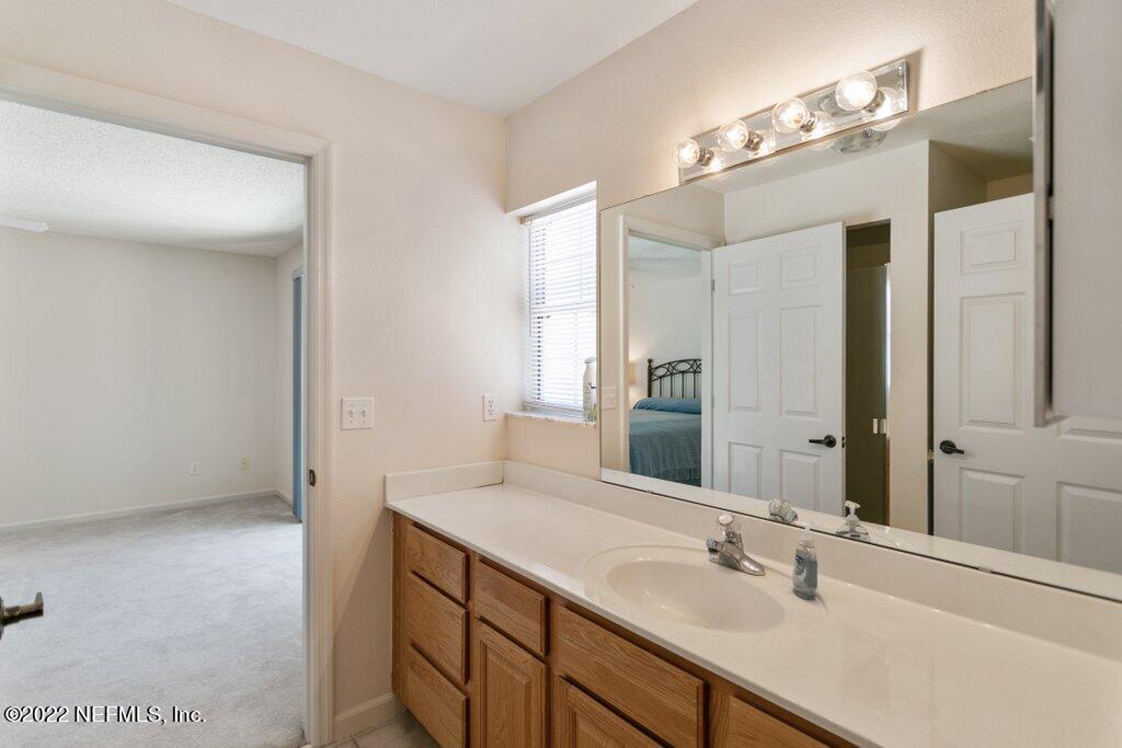 409 Village Drive St. Augustine, FL 32084 - Photo 19 of 75 a bathroom with a sink vanity and mirror