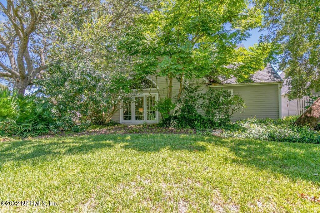 409 Village Drive St. Augustine, FL 32084 - Photo 40 of 75 a view of a backyard with plants and large trees