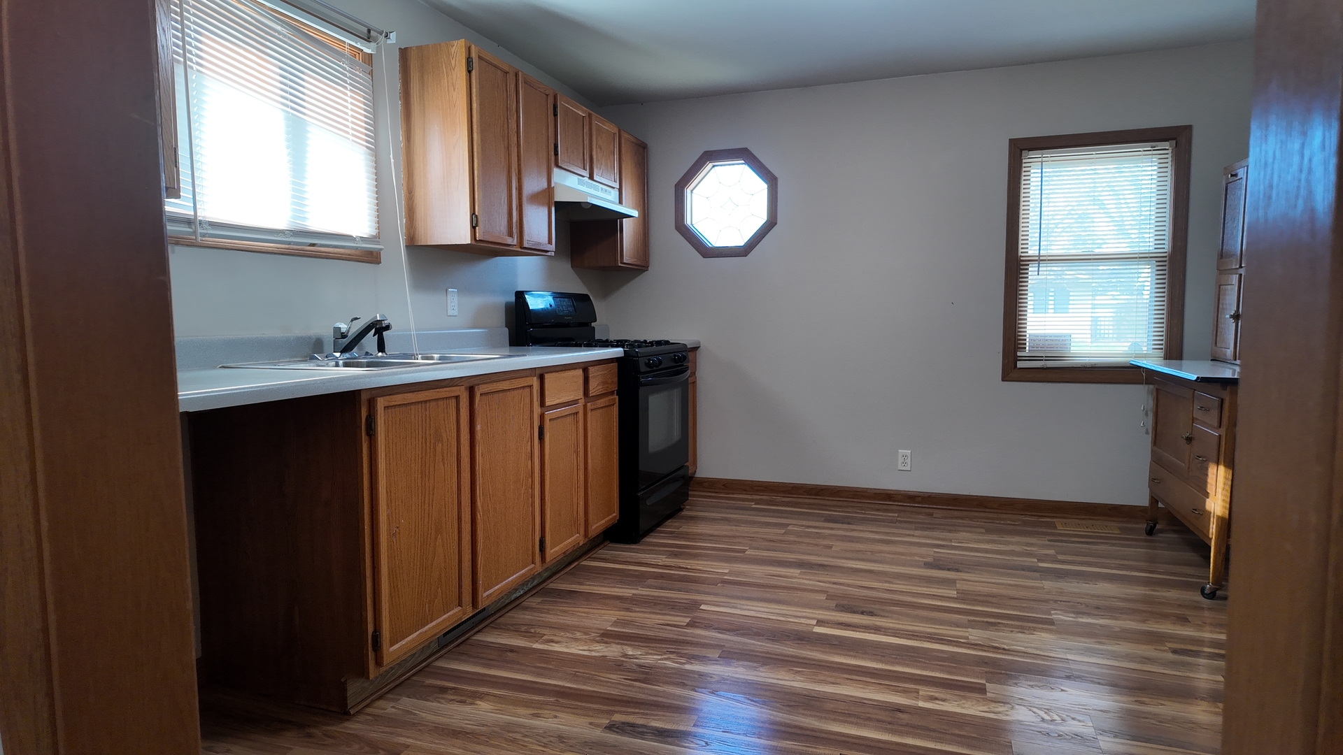 126 Prairie Street Genoa, IL 60135 - Photo 8 of 24 a kitchen with granite countertop a sink cabinets wooden floor and a window