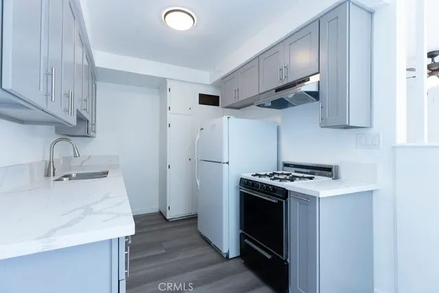 a kitchen with stainless steel appliances granite countertop a sink stove and refrigerator