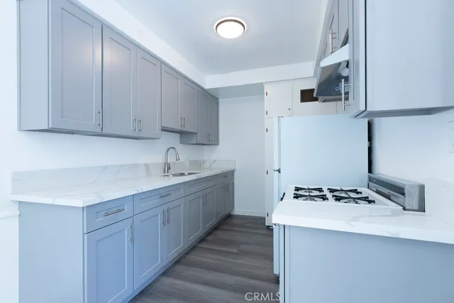 a kitchen with stainless steel appliances a sink stove and cabinets