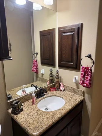 a bathroom with a granite countertop sink and a mirror