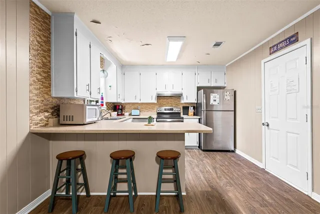 a kitchen with granite countertop white cabinets and white appliances