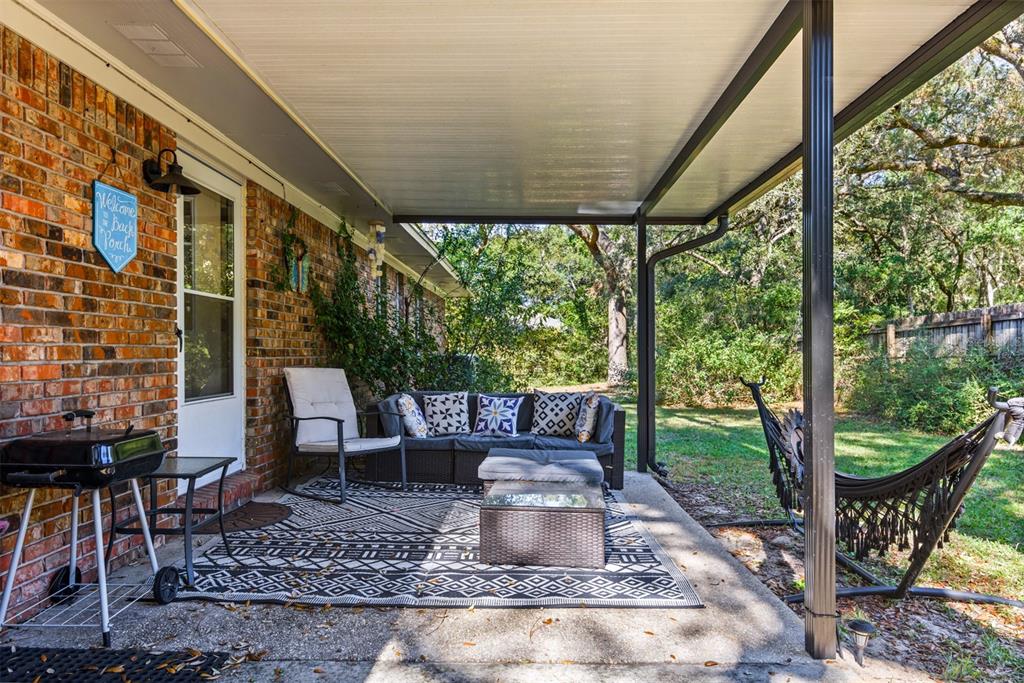 1040 Jocelin Road Pensacola, FL 32506 - Photo 29 of 46 a view of a patio with table and chairs potted plants and floor to ceiling window