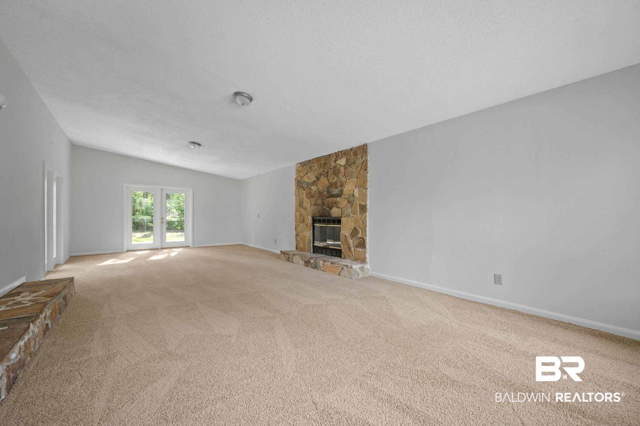 3701 Vista Ridge Drive Mobile, AL 36693 - Photo 19 of 33 Unfurnished living room featuring a textured ceiling, a stone fireplace, and light colored carpet
