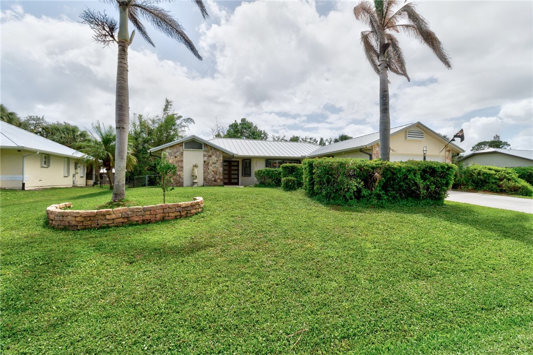 380 Bayfront Terrace Sebastian, FL 32958 - Photo 5 of 32 a front view of a house with a garden and plants