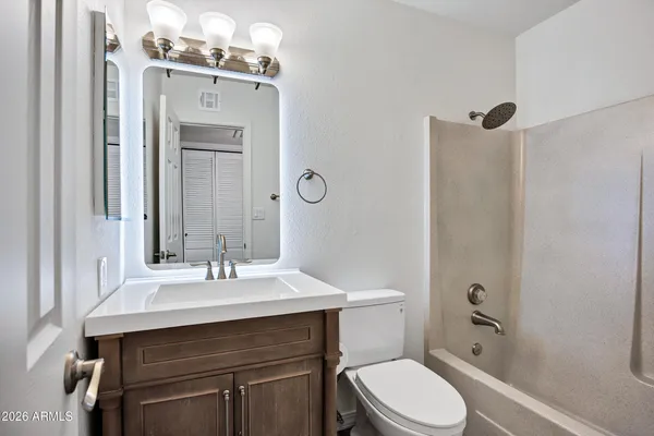 a bathroom with a sink vanity mirror and toilet
