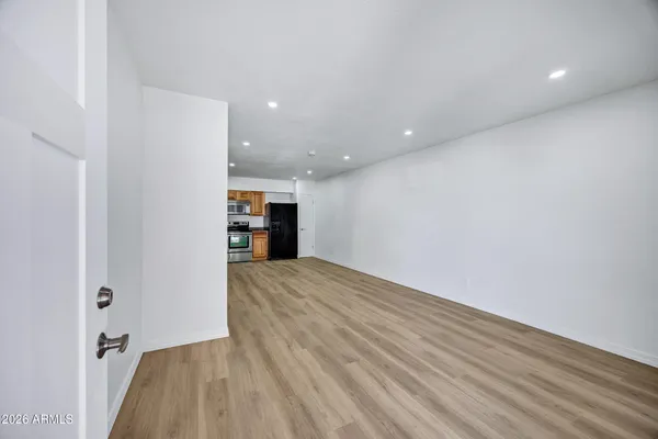 a view of an empty room with a kitchen
