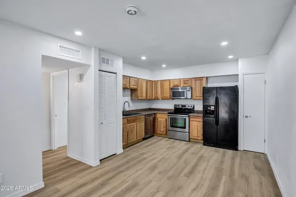 a kitchen with stainless steel appliances granite countertop a refrigerator and a stove top oven