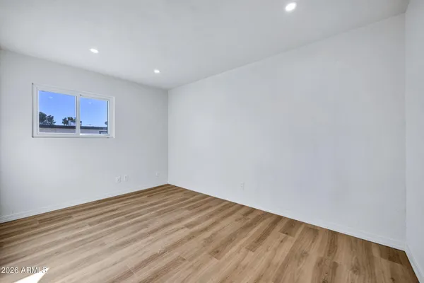 a view of empty room with wooden floor