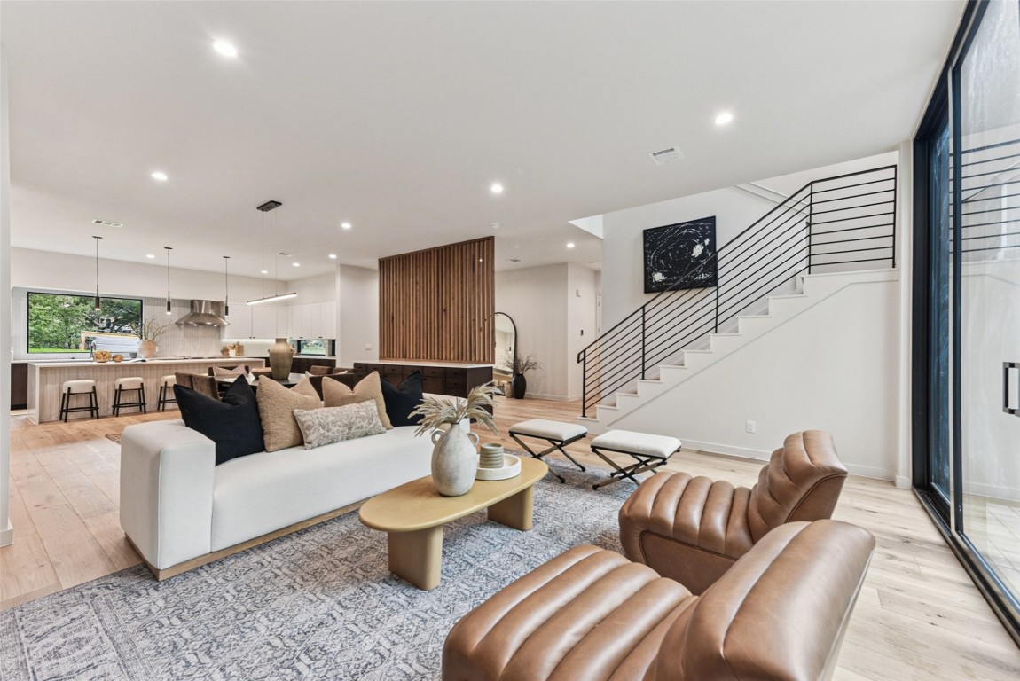 Living room featuring light wood-type flooring, stairs, and recessed lighting